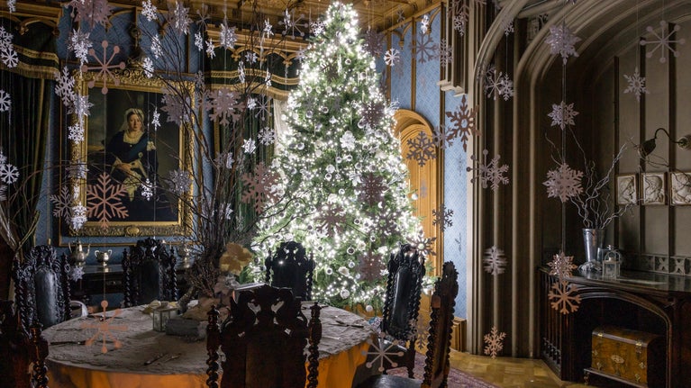 Paper snowflakes falling from the ceiling and large Christmas tree covered in cool white lights